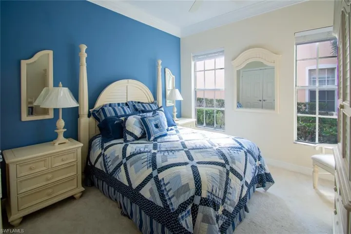 Bedroom featuring ornamental molding, light colored carpet, and ceiling fan