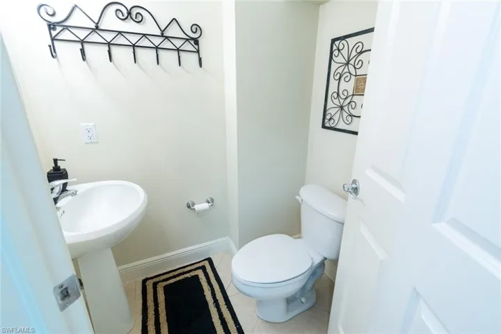 Half bath featuring light tile patterned floors and baseboards