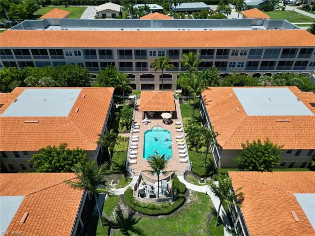 Drone / aerial view of a pool area and apartment complex