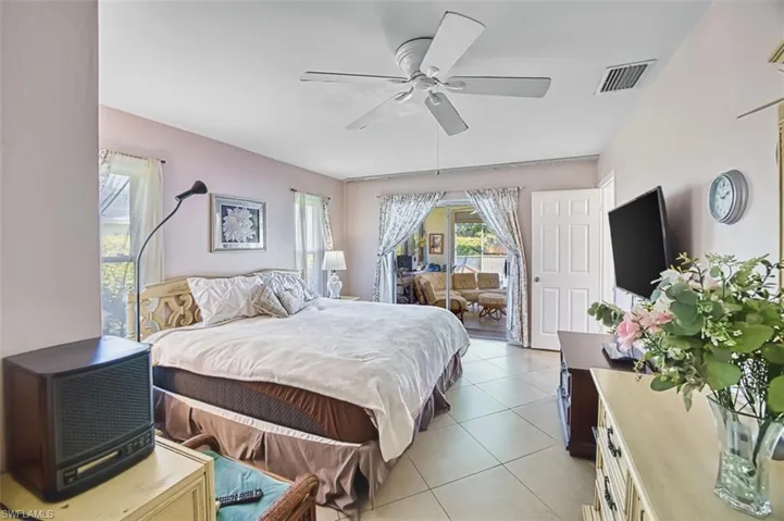 Bedroom with light tile patterned floors and a ceiling fan