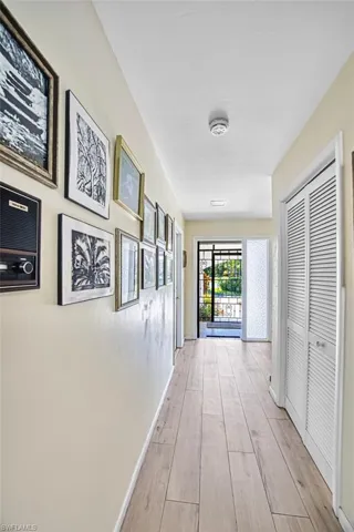 Hallway featuring light wood-type flooring and baseboards