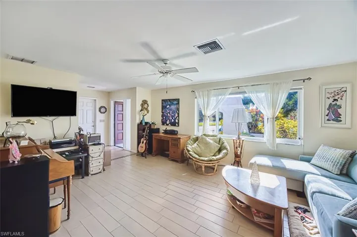 Living room featuring a desk, light wood-type flooring, and ceiling fan