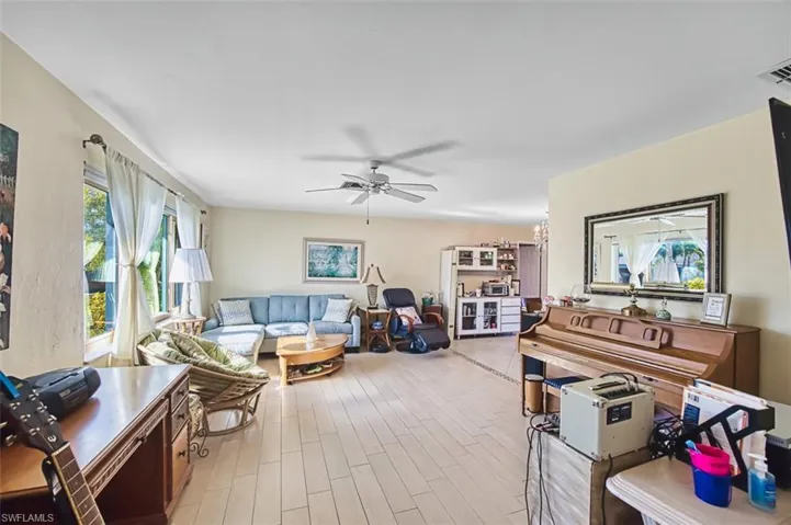 Living room featuring ceiling fan and light wood-style floors