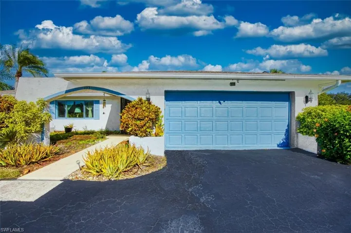 Ranch-style house featuring driveway, stucco siding, and an attached garage