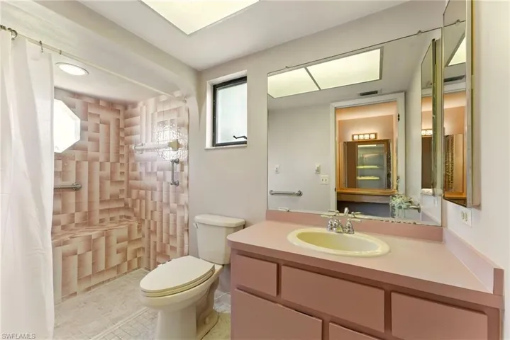 Bathroom featuring a tile shower, vanity, and tile patterned floors