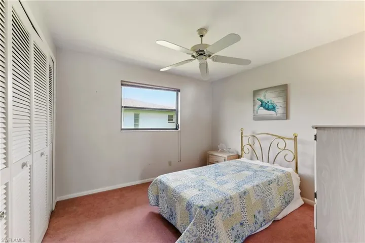Carpeted bedroom featuring a closet and ceiling fan