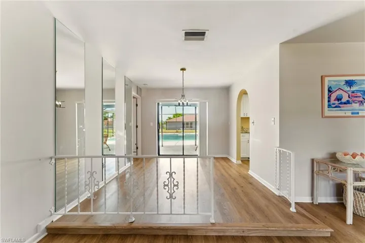 Unfurnished dining area with lvp flooring and arched walkways