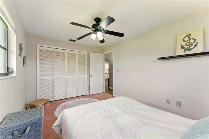 Bedroom with carpet floors, a closet, and ceiling fan