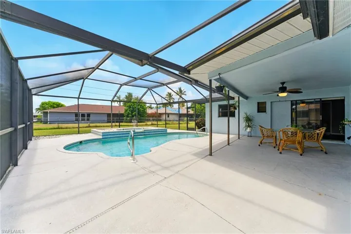 Swimming pool with water fountain, ceiling fan, a patio area, outdoor dining space