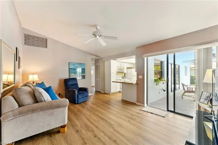 Living area with lvp flooring, ceiling fan, and lofted ceiling