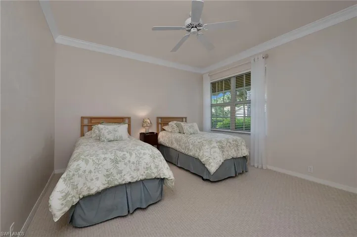 Bedroom with crown molding, ceiling fan, and carpet floors