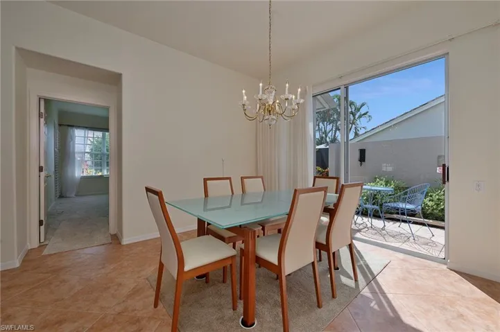 Dining space with a chandelier and light tile patterned flooring