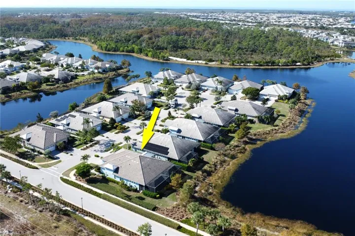 Aerial view of residential area featuring a nearby body of water