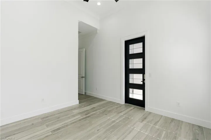Entryway with ornamental molding, light wood finished floors, recessed lighting, and ceiling fan