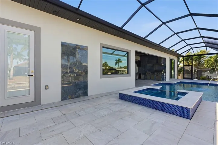 Pool at dusk featuring a saltwater pool and Jacuzzi
