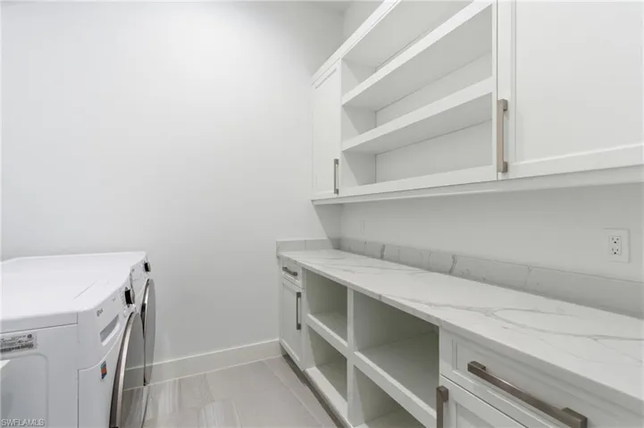 Laundry area with baseboards and washer and clothes dryer