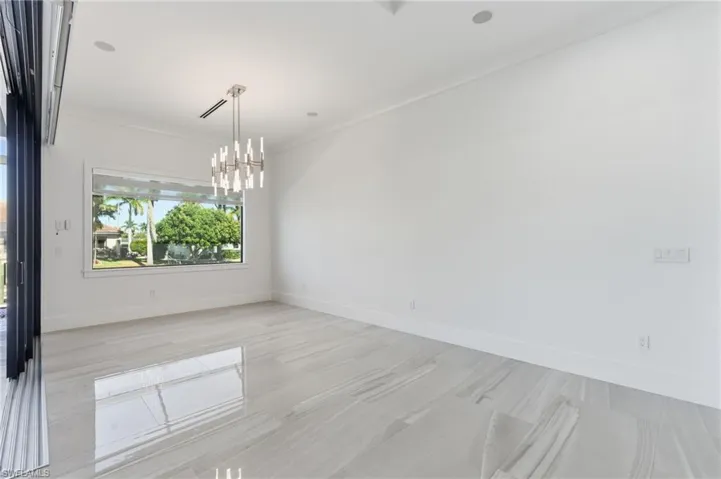 Unfurnished room with a chandelier and ornamental molding