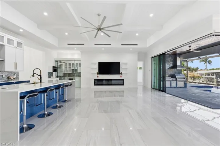 Living room featuring a ceiling fan, beamed ceiling, coffered ceiling, and recessed lighting