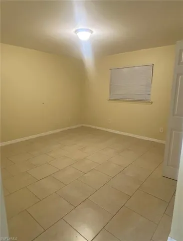 Spare room featuring light tile patterned floors and baseboards