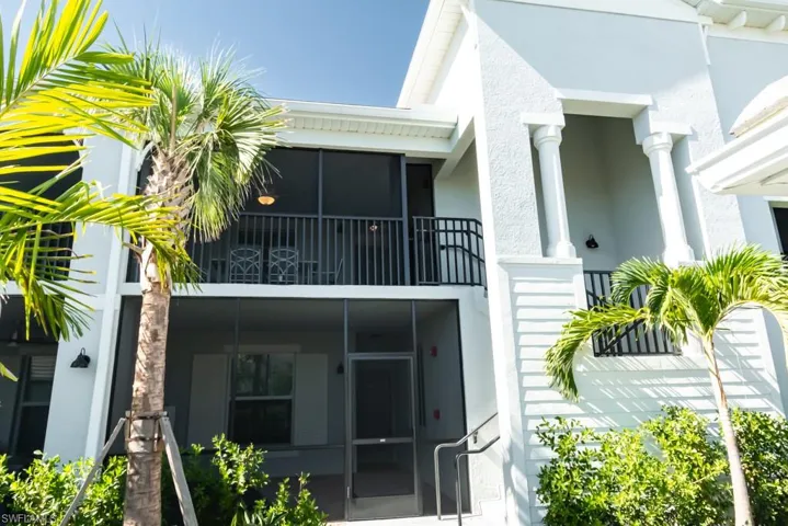 Rear view of property with stucco siding and a sunroom