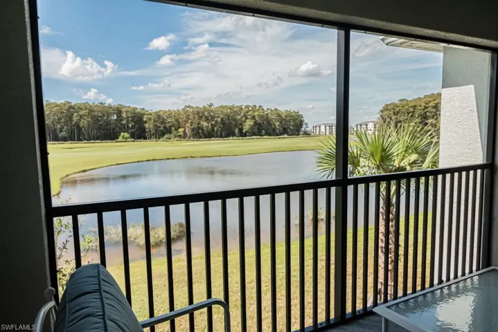 Balcony featuring a water view, golf course view, and view of scattered trees