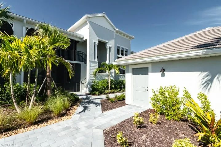 View of exterior entry featuring stucco siding, a tiled roof, and a balcony