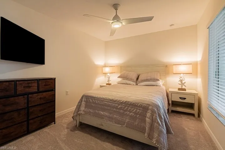 Carpeted bedroom featuring baseboards and a ceiling fan