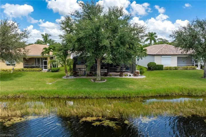 Rear view of house featuring a lawn and a water view