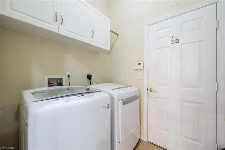Laundry room with independent washer and dryer and cabinets