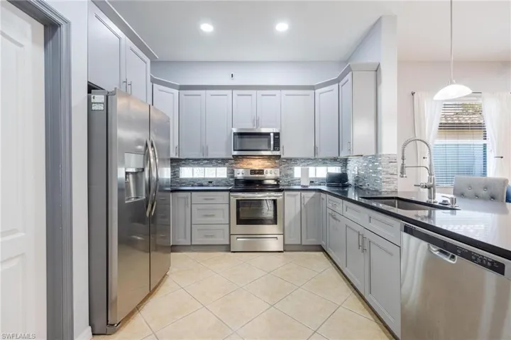 Kitchen featuring gray cabinetry and appliances with stainless steel finishes