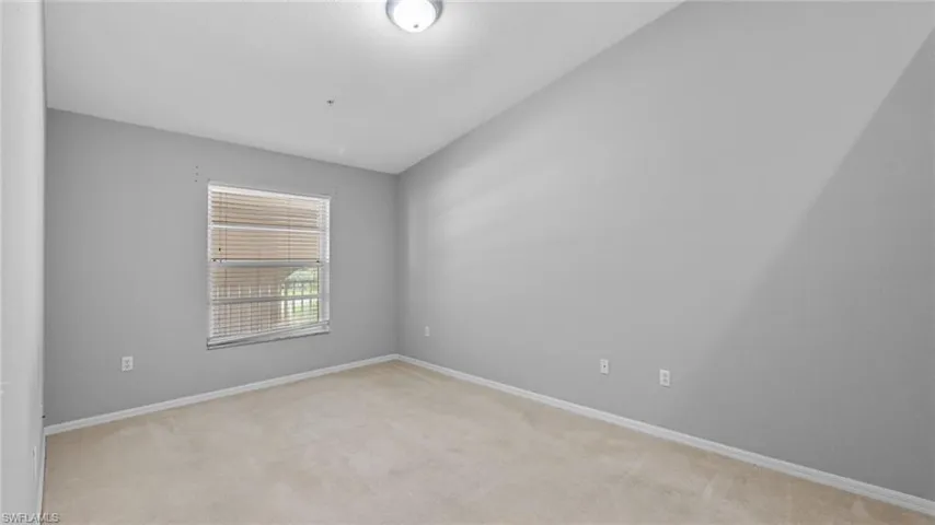 Spare room with light carpet and vaulted ceiling