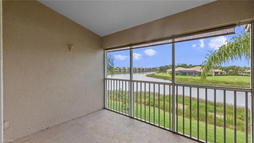 Unfurnished sunroom featuring a water view, vaulted ceiling, and a residential view