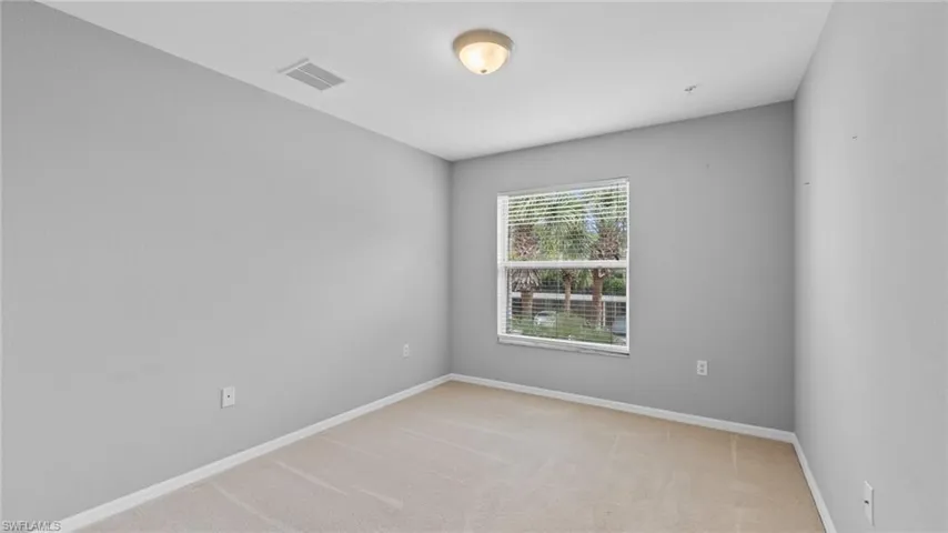 Spare room with light carpet and baseboards