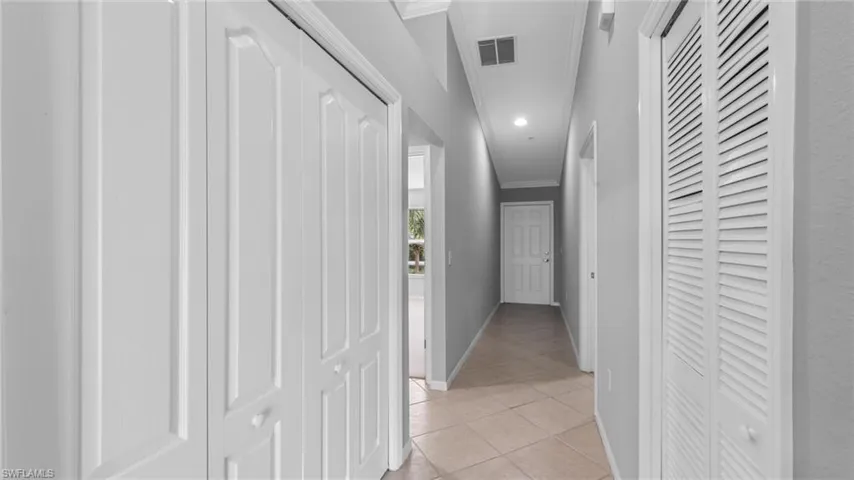 Corridor featuring ornamental molding and light tile patterned floors