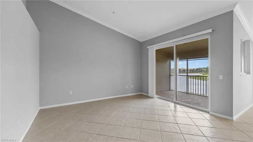 Unfurnished room with ornamental molding, light tile patterned floors, lofted ceiling, and a water view