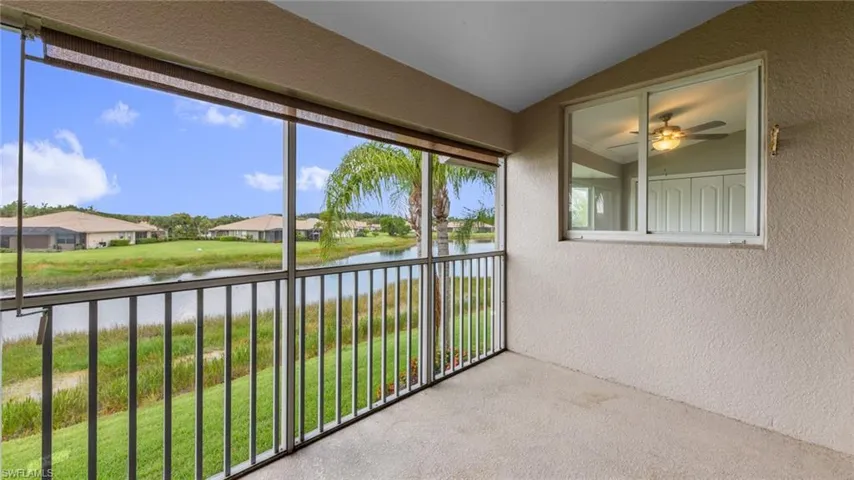 Unfurnished sunroom featuring a water view, lofted ceiling, and a residential view