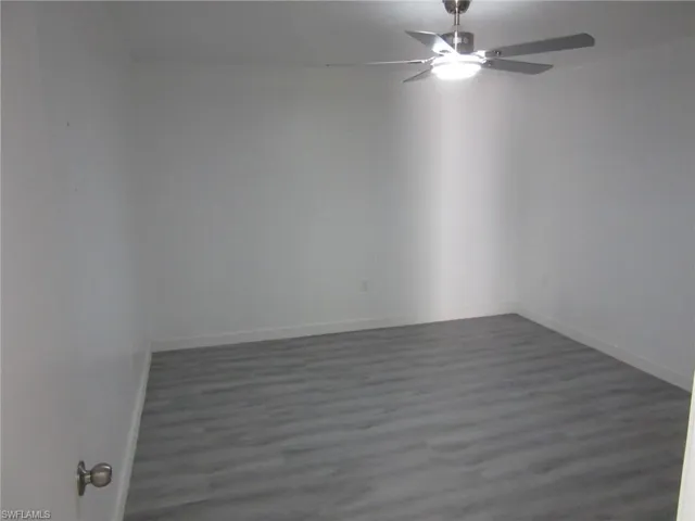 Spare room with baseboards, wood finished floors, and a ceiling fan