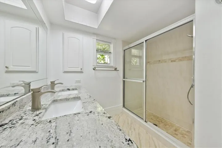 Full bath with a tile shower and double vanity