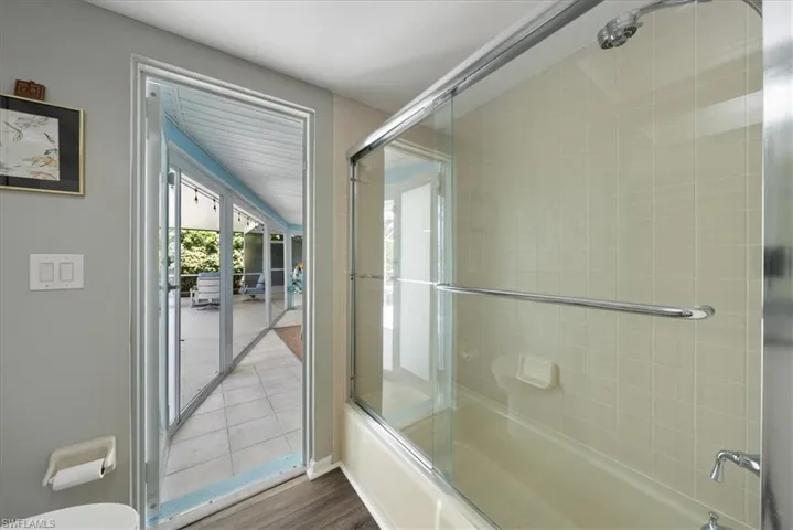 Bathroom with combined bath / shower with glass door and