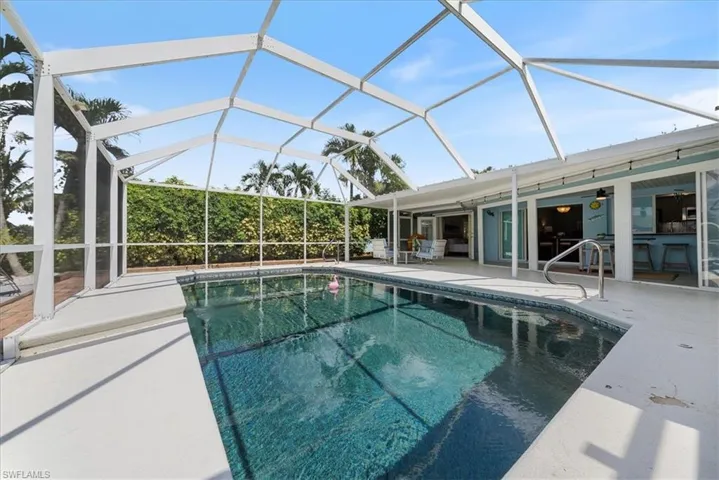 Swimming pool featuring a patio area, ceiling fan, and glass enclosure