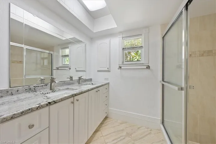 Full bathroom with a shower stall, double vanity,