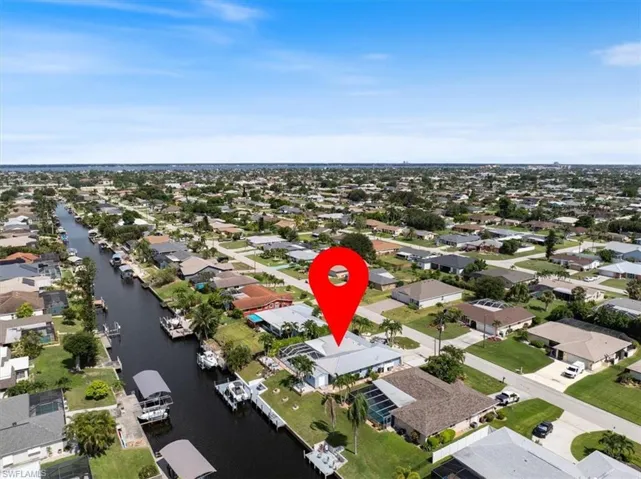 Aerial view of property and surrounding area featuring nearby suburban area