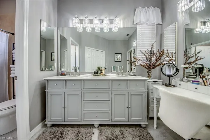 Dual vanity with integrated sinks, brushed nickel fixtures, and a multi-bulb light bar