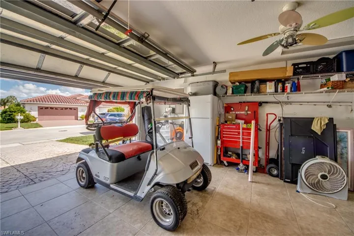 Garage featuring a ceiling fan, overhead shelving, and tiled flooring