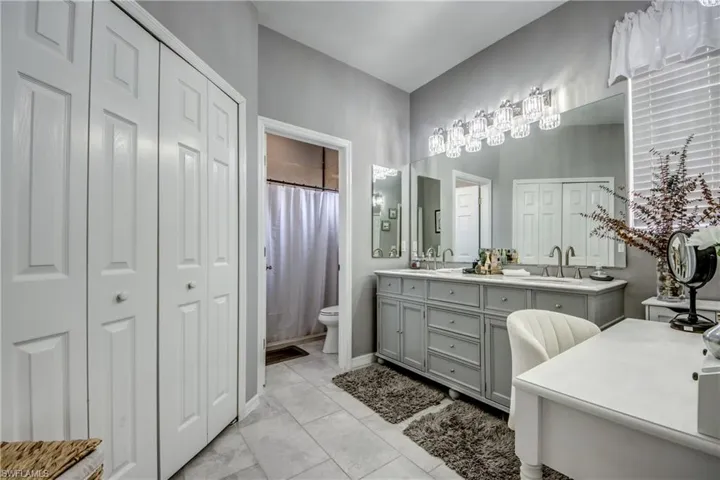 Double vanity with integrated sinks, expansive wall mirror, and crystal-detail lighting fixtures