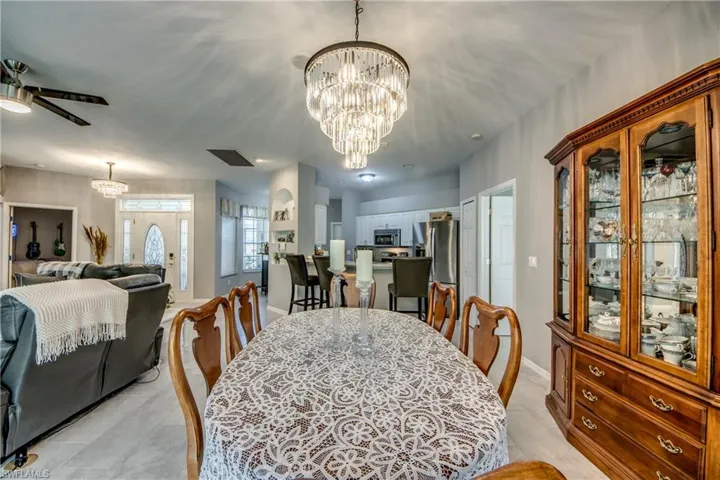 Recessed lighting, chandelier, ceiling fan, tile flooring, and arched entryway