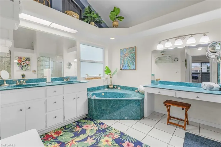 Bathroom featuring a bath, tile patterned floors, double vanity, and a stall shower
