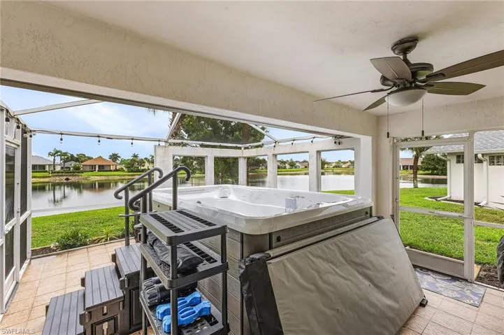 Sunroom / solarium featuring a water view and ceiling fan