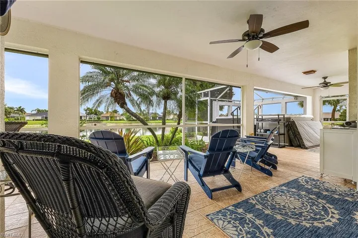 Sunroom / solarium featuring a water view and a ceiling fan