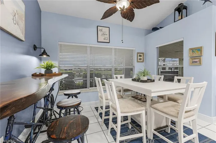 Dining space featuring a ceiling fan, light tile patterned floors, and baseboards